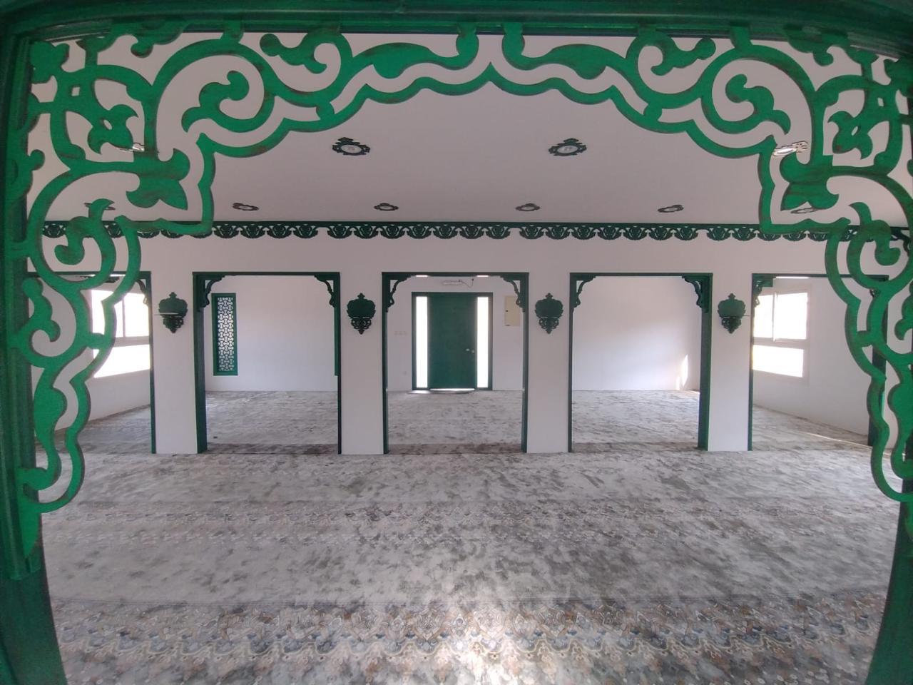 مسجد الربيع بنت معوذ رضي الله عنها — الإطارات الخضراء المتتابعة والأبواب داخل قاعة الصلاة